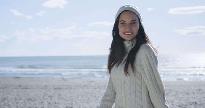 Portrait Of A Young Woman In Autumn Clothes Smiling On The Beach