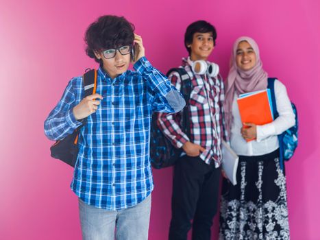 A group of Arab teenagers, a student team walking forward into the future and back to school the concept of a pink background. The concept of successful education for young people. Selective focus. High quality photo