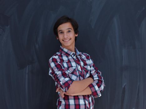 arab teenager with wearing  casual school look against black chalkboard background