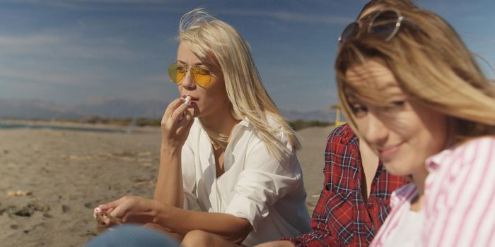 Group Of Young girlfriends Spending The Day On A Beach during autumn day