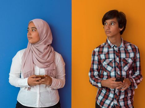 Arab teenagers group using smartphones for social media networking and sharing information for online education. High quality photo. Selective focus 