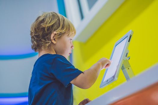 Boy playing with digital tablet. Children and technology concept.