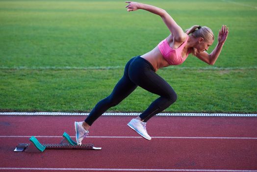 pixelated design of woman  sprinter leaving starting blocks on the athletic  track. Side view. exploding start