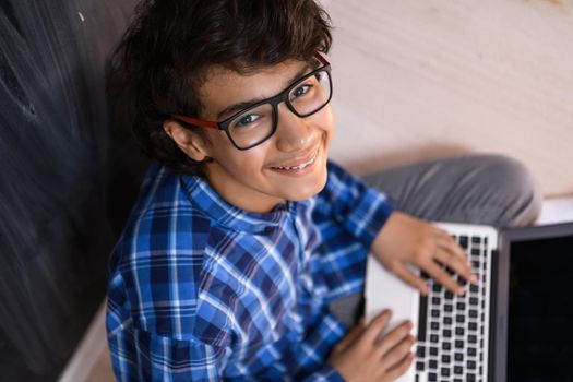 Arab teenagers using laptops to work on homework and watch online education while staying at home cause coronavirus pandemic quarantine. High quality photo