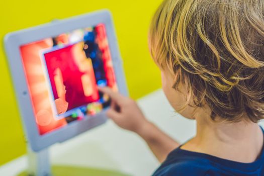 Boy playing with digital tablet. Children and technology concept.