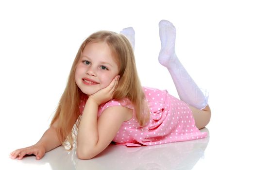 Beautiful little girl lies on the floor on a white background. The concept of a happy childhood, well-being in the family. Isolated.