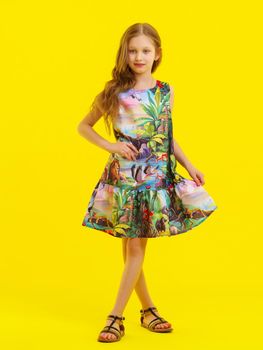 Charming little girl in a light summer dress. Concept of family vacation, happy childhood. In isolation.