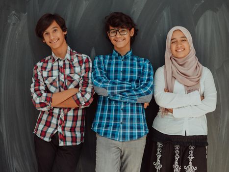 A portrait of a group of Arab teenagers with crossed arms standing in front of a school board. The concept of modern and successful education. High quality photo