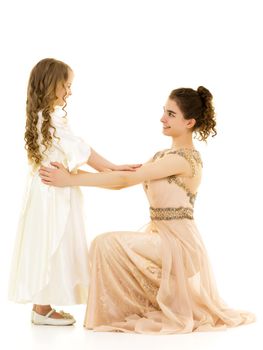 Beautiful young girl hugging her little sister. The concept of a happy childhood, family values. Isolated on white background.