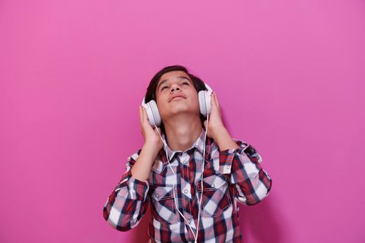 Arabic Teenage Boy Wearing Headphones And Listening To Music pink background