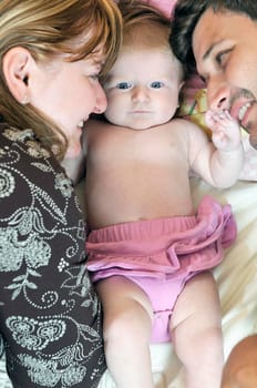 indoor portrait with happy young family and  cute little babby