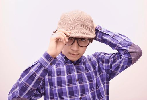 portrait  of smart looking arab teenager with glasses wearing a hat in casual school look isolated on white copy space