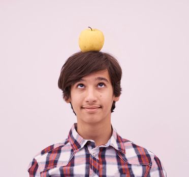 portrait of a young Arab teen boy with an apple on his head as target  isolated on white background