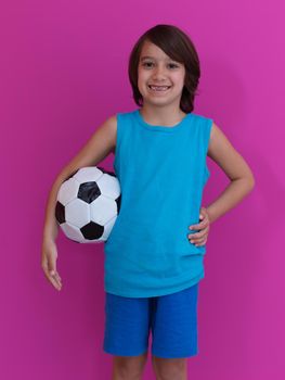 Portrait of young Arabic boy with soccer ball isolated against  pink background and copy space