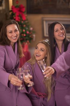 three young beautiful happy girls have a bachelor party at a luxury spa with champagne