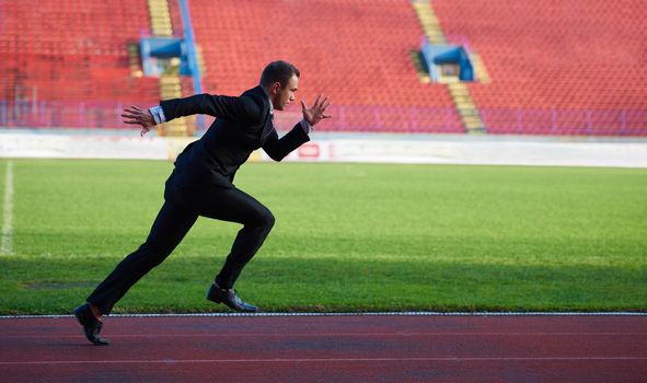 business man in start position ready to run and sprint on athletics racing track