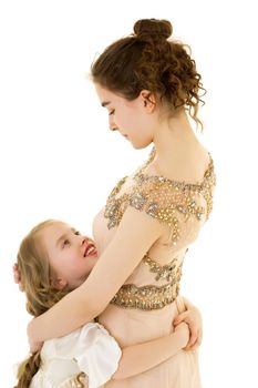 Beautiful young girl hugging her little sister. The concept of a happy childhood, family values. Isolated on white background.