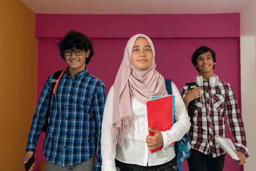 A group of Arab teenagers, a student team walking forward into the future and back to school the concept of a pink background. The concept of successful education for young people. Selective focus. High quality photo