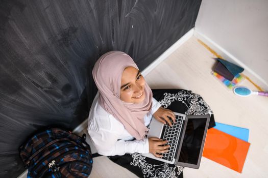 Arab female student working on laptop from the home top view. High quality photo