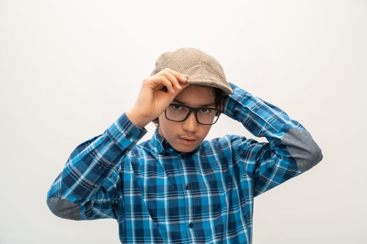portrait of smart-looking Arab teenager with glasses wearing a hat in casual school look isolated on white copy space. High quality photo