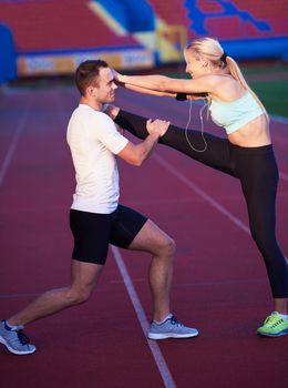 young runner sporty woman relaxing and stretching on athletic race track