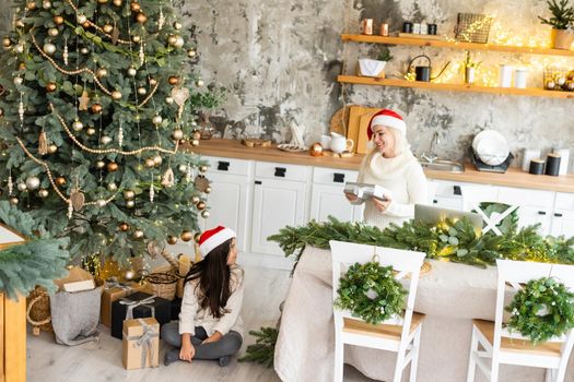 Friendship and love of mom and daughter. Family values. Preparing to celebrate Christmas. Christmas tree decoration. Building a good relationship between mother and daughter