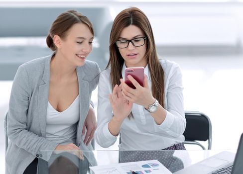two business women looking at the smartphone screen. business and technology