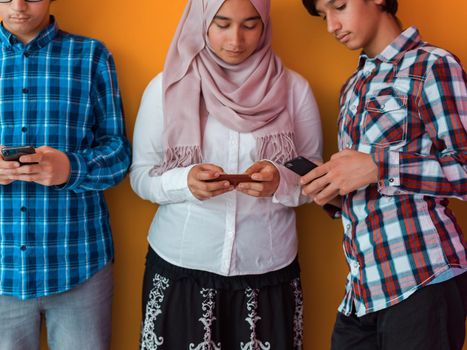 Arab teenagers group using smartphones for social media networking and sharing information for online education. High quality photo. Selective focus 