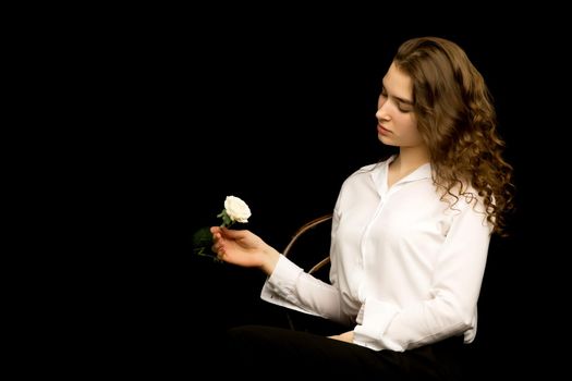 Cute little girl with white flower on a black background. The concept of style and fashion.