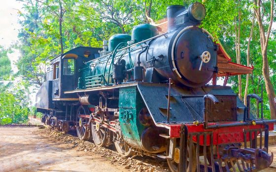 An old steam locomotive stands on a perpetual parking lot covered with rust and road dust. He will never go anywhere. The concept of the railway, the history of steam machines.