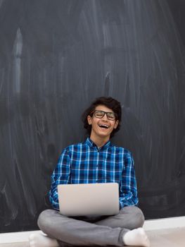 Arab teenagers using laptops to work on homework and watch online education while staying at home cause coronavirus pandemic quarantine. High quality photo