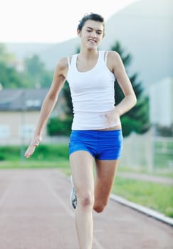 beautiful young woman exercise jogging and runing on athletic track on stadium at sunrise 