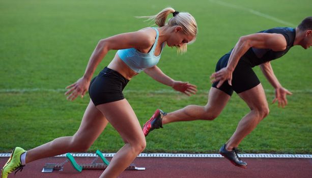 athlete woman group  running on athletics race track on soccer stadium and representing competition and leadership concept in sport