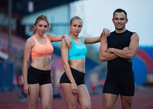 young runner sporty woman relaxing and stretching on athletic race track