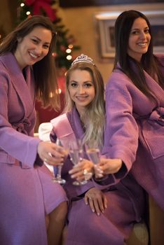 three young beautiful happy girls have a bachelor party at a luxury spa with champagne