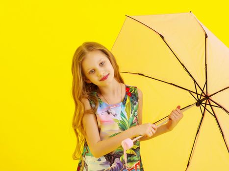 A nice little girl hid under an umbrella. The concept of a happy childhood, outdoor recreation, protection from bad weather. Isolated.