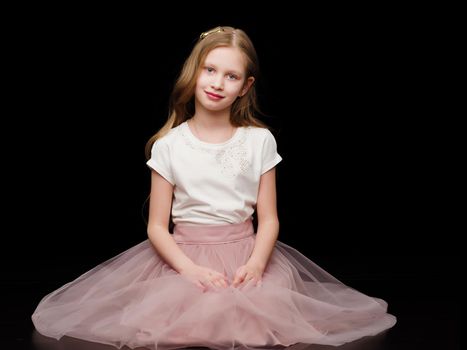 Beautiful little girl on a black background. Studio photography