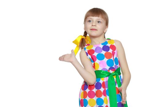 A sweet little blonde girl with long pigtails, in which large colored bows are braided, and a short bangs on her head. In a short summer dress.She gestures.