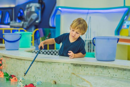 Cute boy in the playroom fishing. The development of fine motor concept. Creativity Game concept.