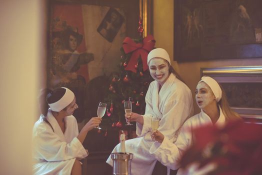 three young beautiful happy girls have a bachelor party at a luxury spa with champagne