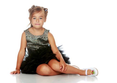 Little girl is sitting on the floor. The concept of a happy childhood. Isolated on white background.