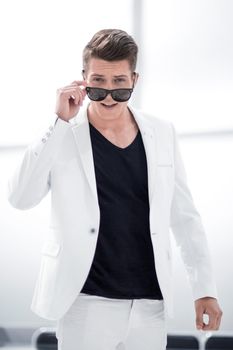 Handsome stylish man in white elegant suit and sunglasses