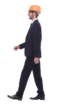 in full growth. businessman in a protective helmet, stepping forward
