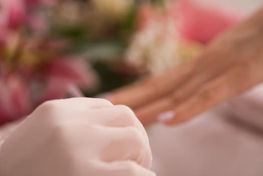 Woman hands receiving a manicure in beauty salon. Nail filing. Close up, selective focus.