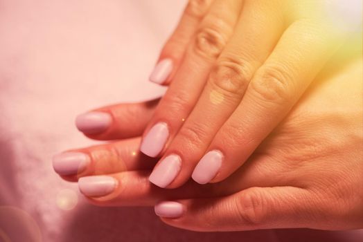 Beautiful fingers with french manicure on the towel. Manicure in a beauty salon.