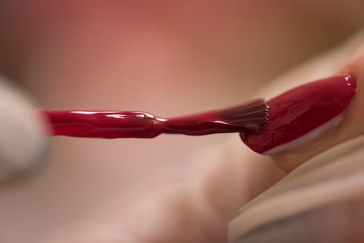 Woman hands receiving a manicure in beauty salon. Nail filing. Close up, selective focus.