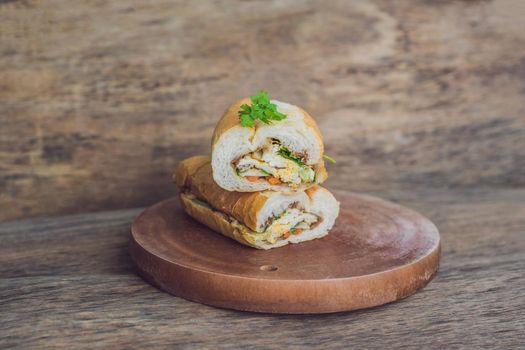 A delicious Vietnamese Bahn Mi sandwich on a wooden background.