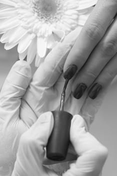 Woman hands receiving a manicure in beauty salon. Nail filing. Close up, selective focus.