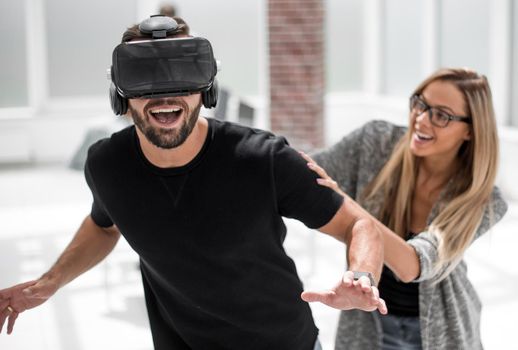 Positive man wearing virtual reality glasses and smiling while testing new technology