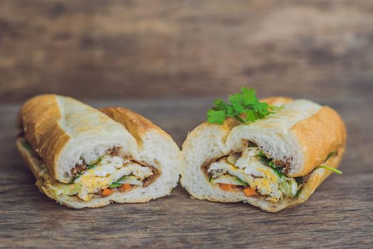 A delicious Vietnamese Bahn Mi sandwich on a wooden background.